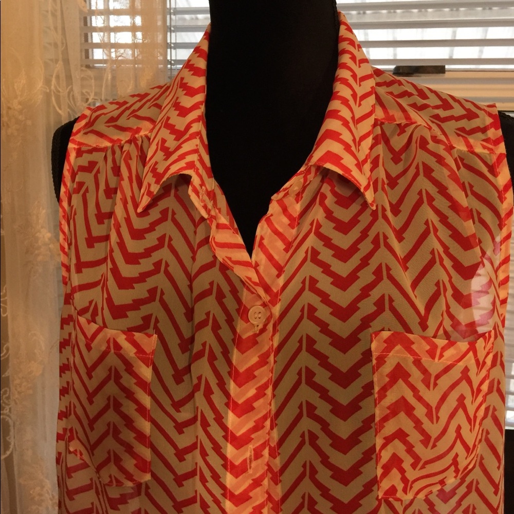 Sleeveless top with cut pattern. Orange and white